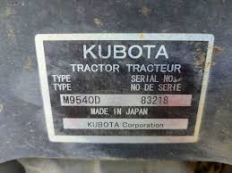 Close-up of a Kubota tractor model and serial number plate mounted on the frame